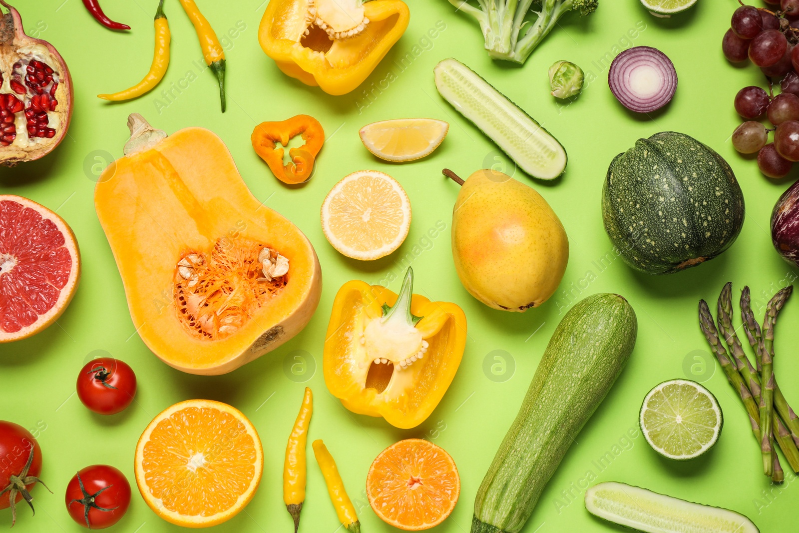 Photo of Fresh organic fruits and vegetables on green background, flat lay