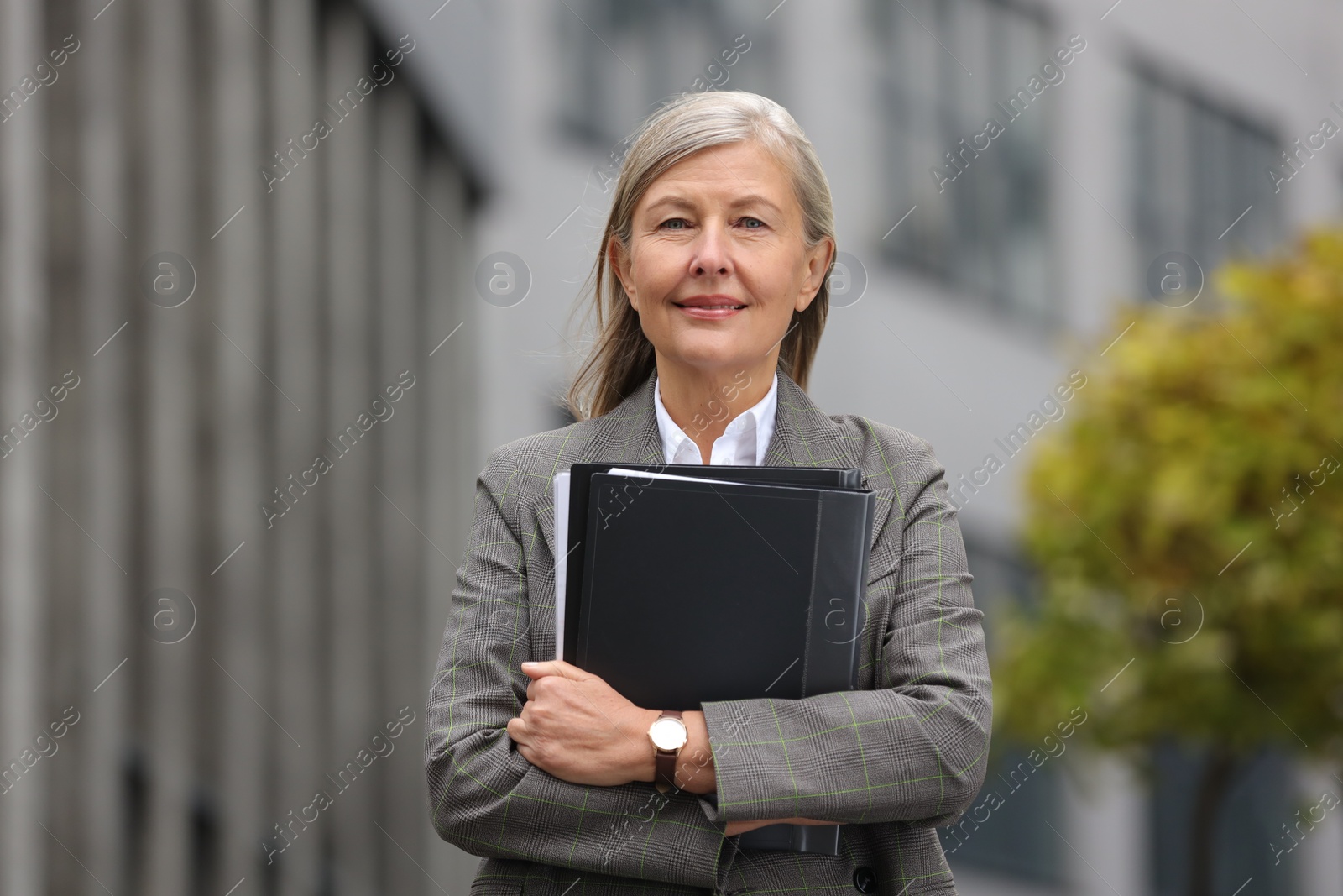 Photo of Beautiful woman with folders outdoors. Lawyer, businesswoman, accountant or manager