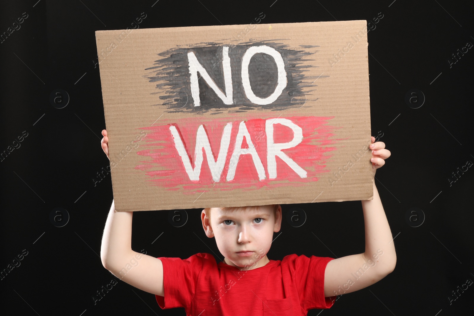 Photo of Boy holding poster No War against black background