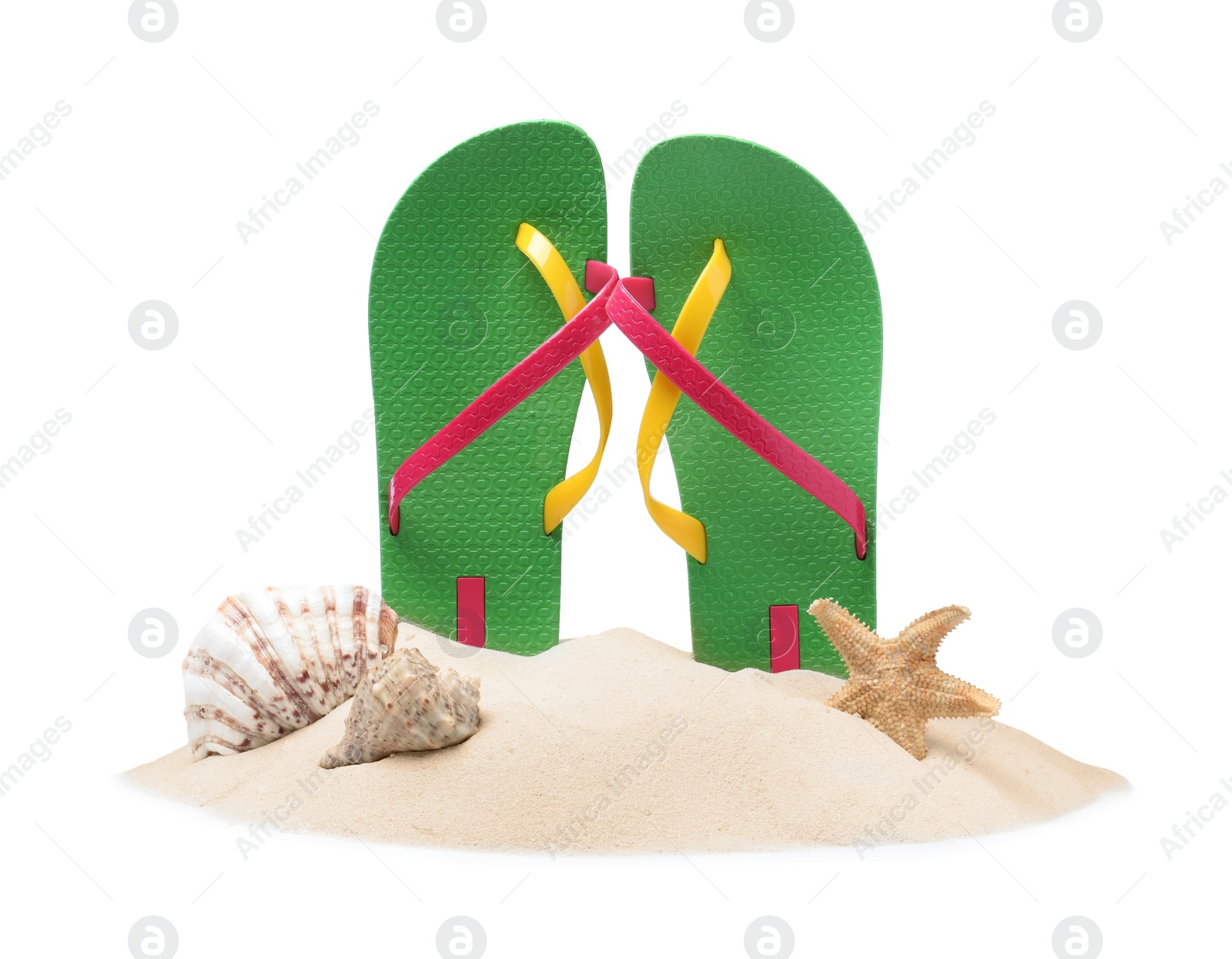 Photo of Green flip flops in sand, starfish and sea shells on white background