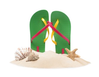Photo of Green flip flops in sand, starfish and sea shells on white background