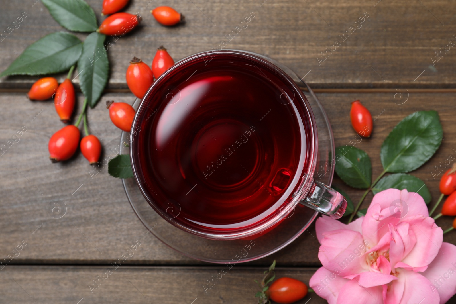 Photo of Flat lay composition with aromatic rose hip tea on wooden table