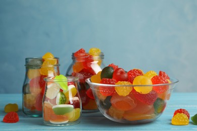 Delicious gummy candies on light blue wooden table