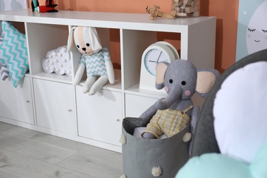 Photo of Cute child's room interior with toys and modern furniture