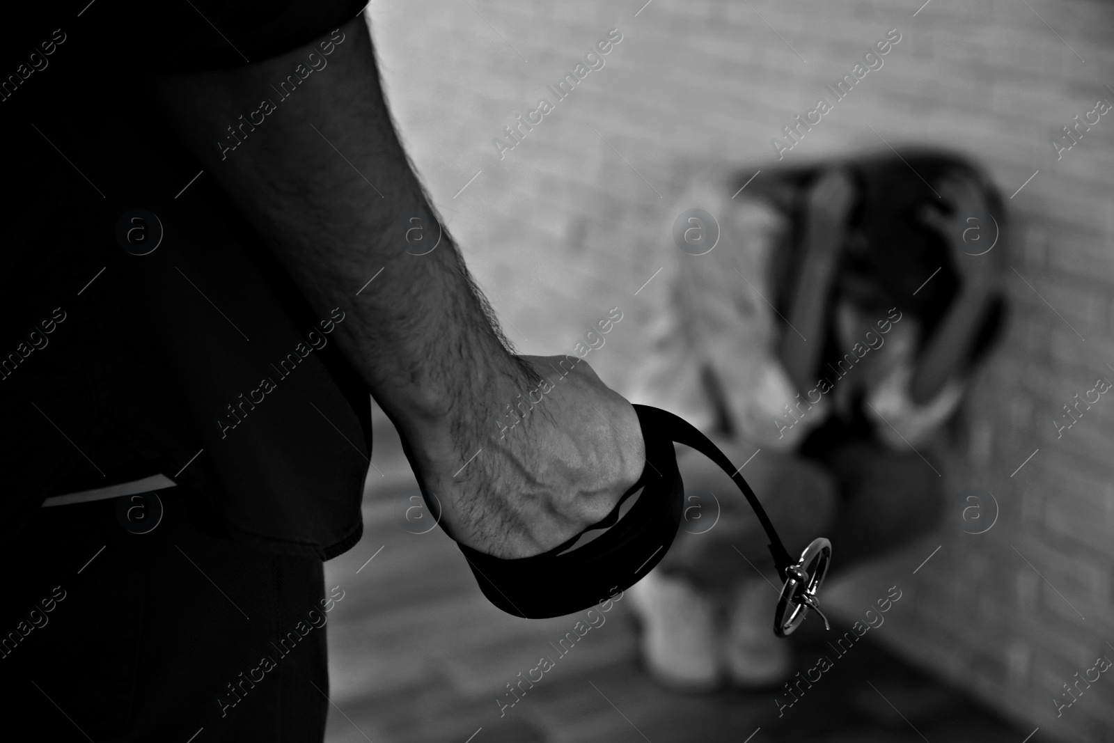 Image of Man threatening woman with belt indoors, closeup. Domestic violence