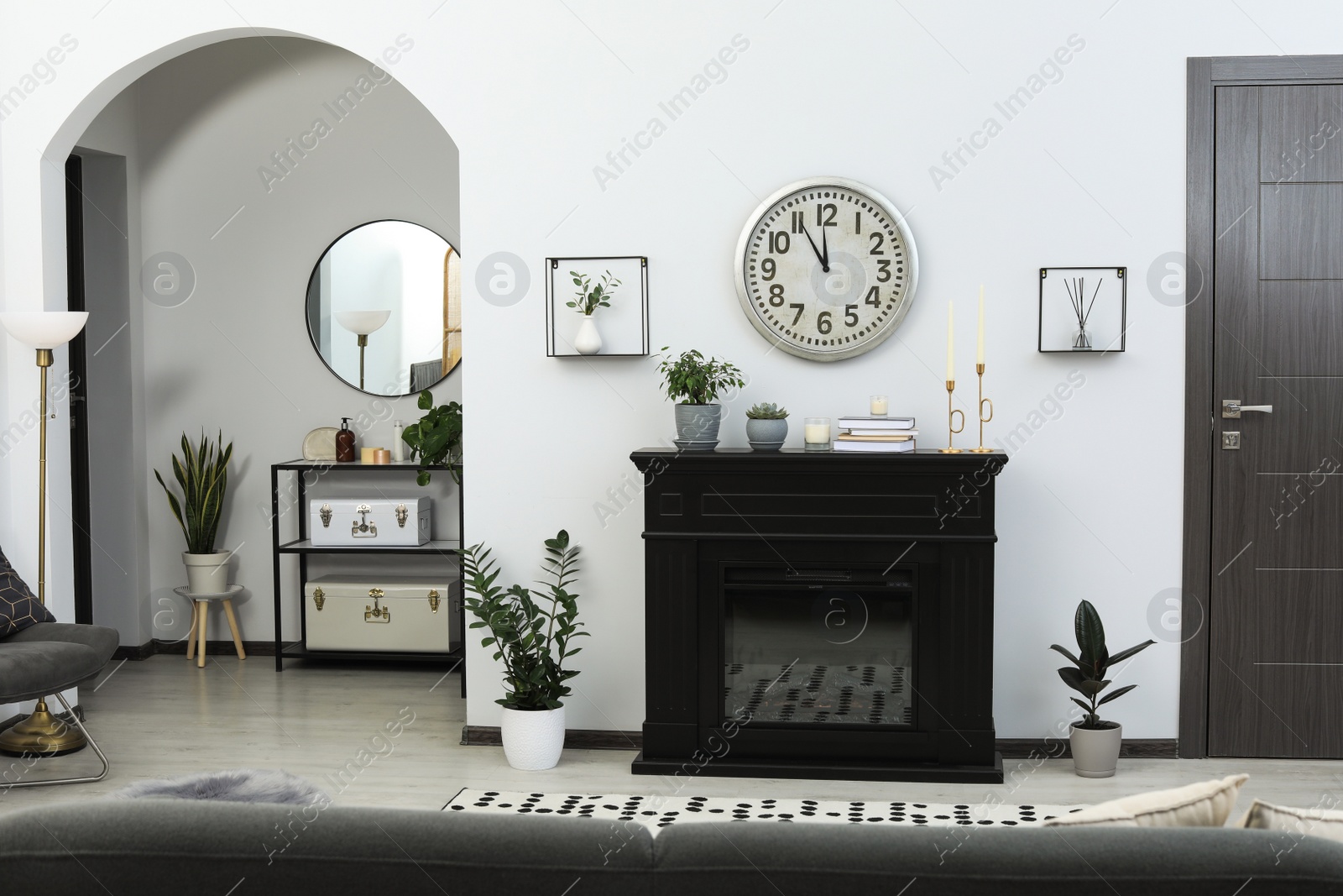 Photo of Stylish living room interior with fireplace and green plants