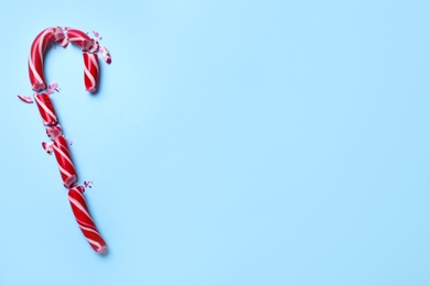 Photo of Crushed Christmas candy cane on light blue background, top view. Space for text