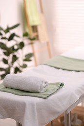 Rolled towel on massage table in spa center