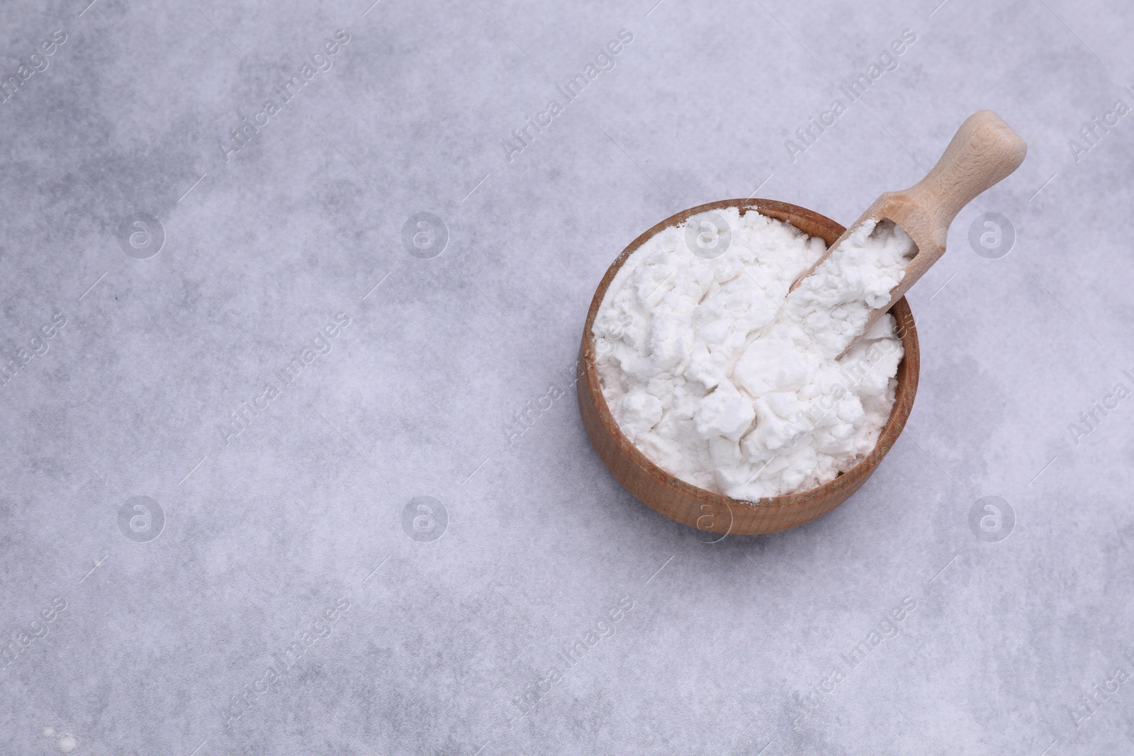 Photo of Scoop and bowl of starch on light gray table, top view. Space for text