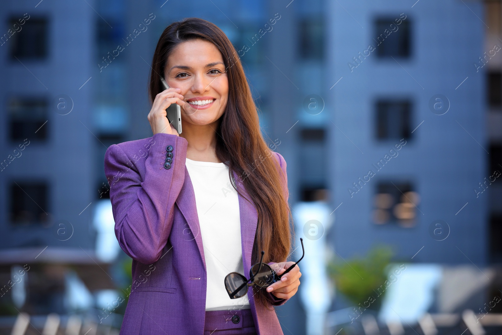 Photo of Beautiful businesswoman talking on phone outdoors. Space for text