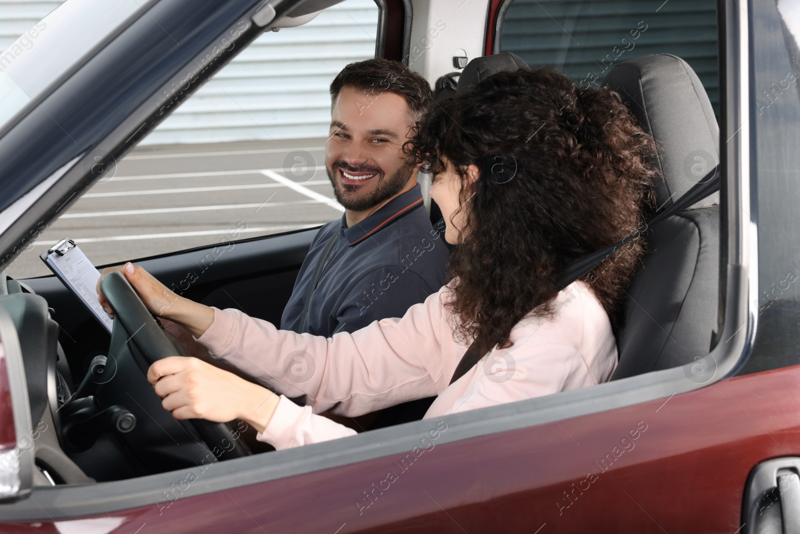 Photo of Driving school. Happy student passing driving test with examiner in car