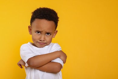 Photo of Emotional African-American boy on yellow background. Space for text