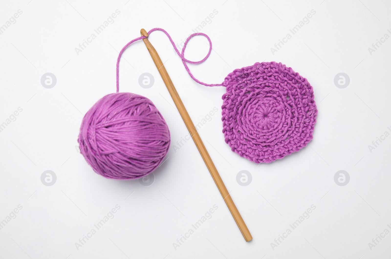 Photo of Soft violet woolen yarn, knitting and crochet hook on white background, top view
