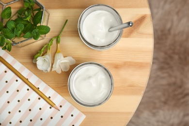 Photo of Jars with yummy yogurt on wooden table