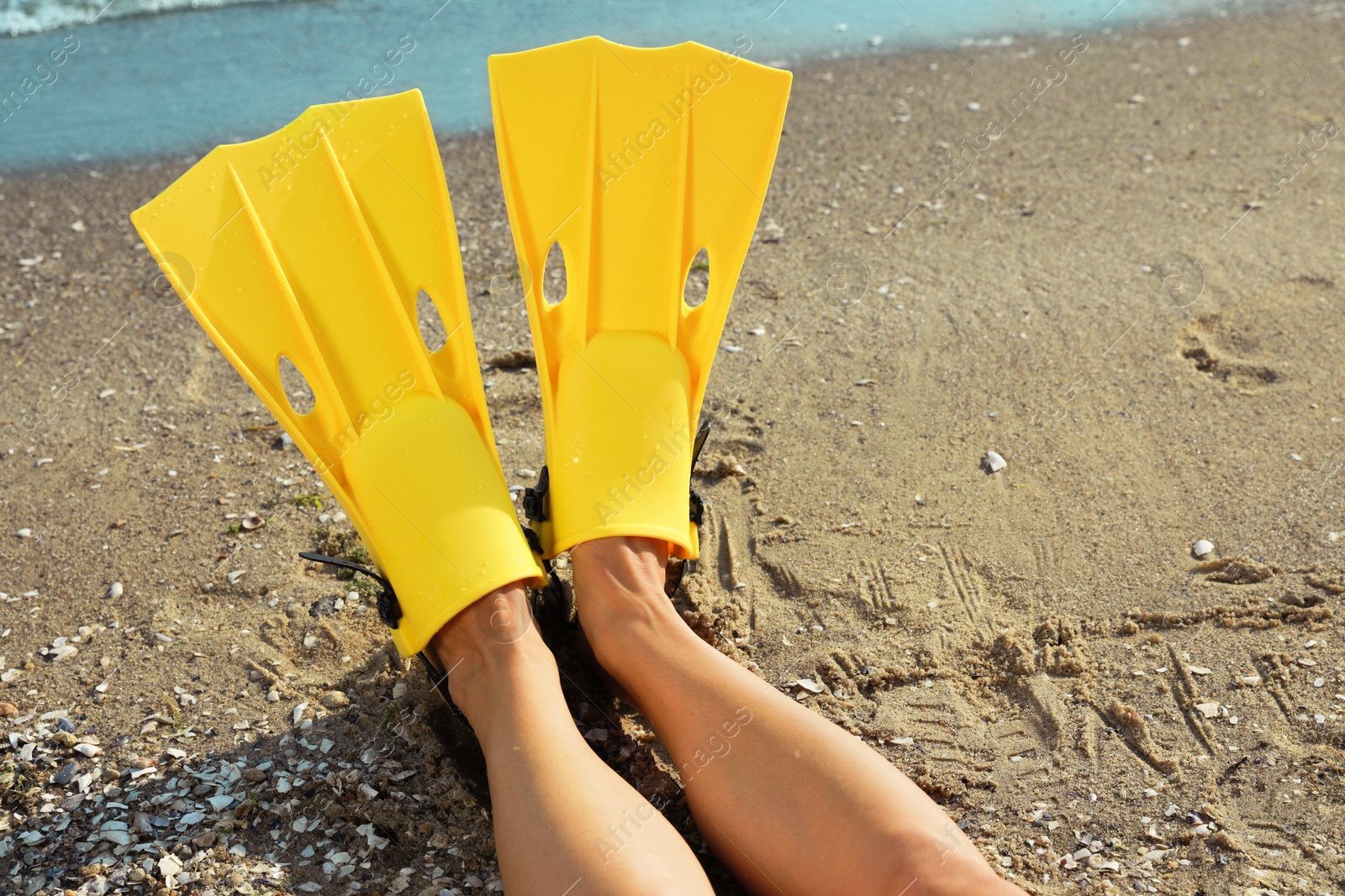 Photo of Woman in yellow flippers on beach, closeup