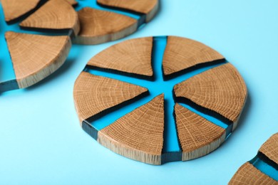 Photo of Stylish wooden cup coasters on light blue background