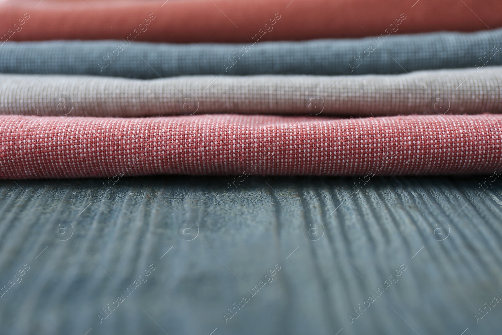 Photo of Different colorful napkins on wooden table, closeup. Space for text