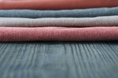 Photo of Different colorful napkins on wooden table, closeup. Space for text