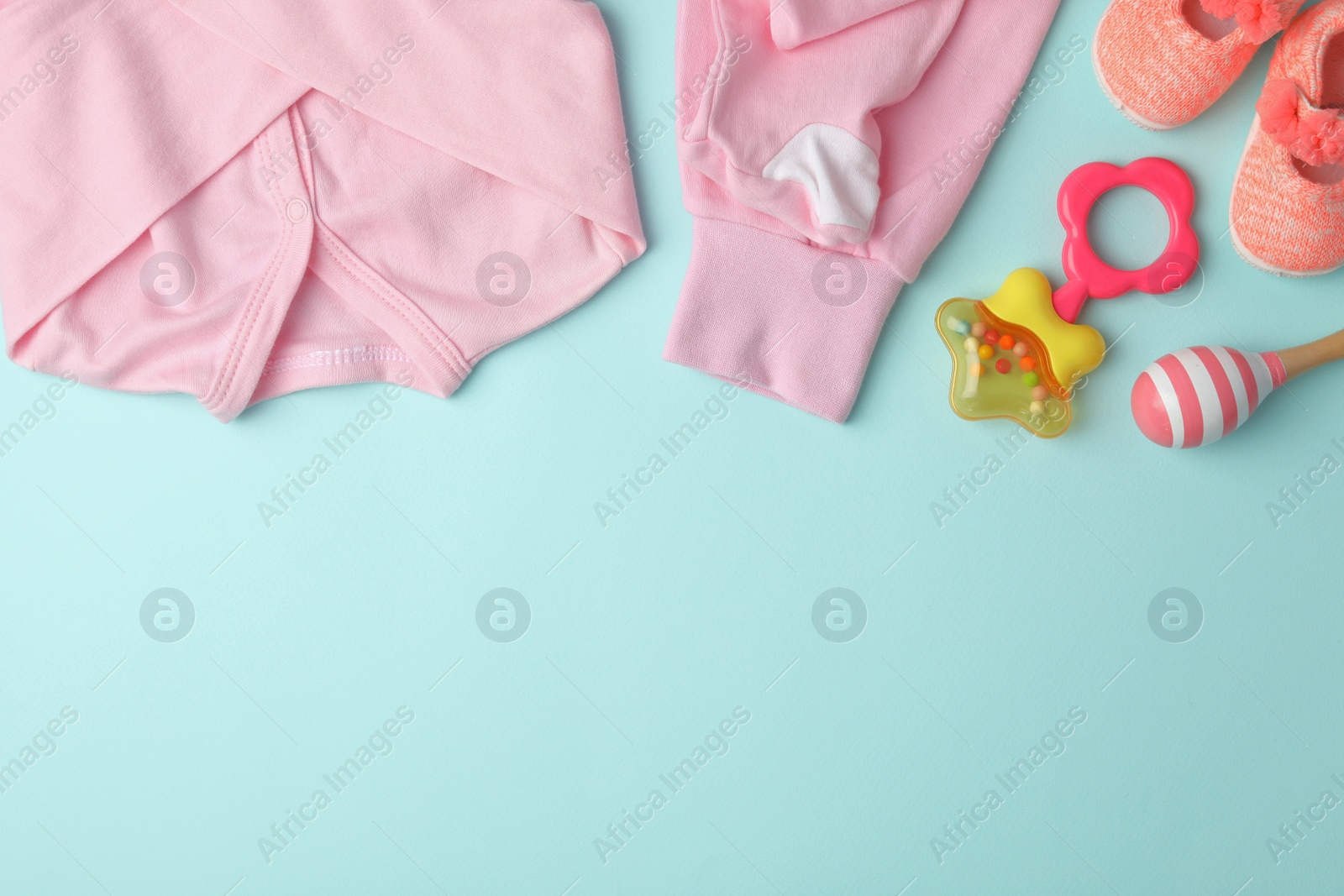 Photo of Flat lay composition with child's clothes and accessories on light blue background, space for text