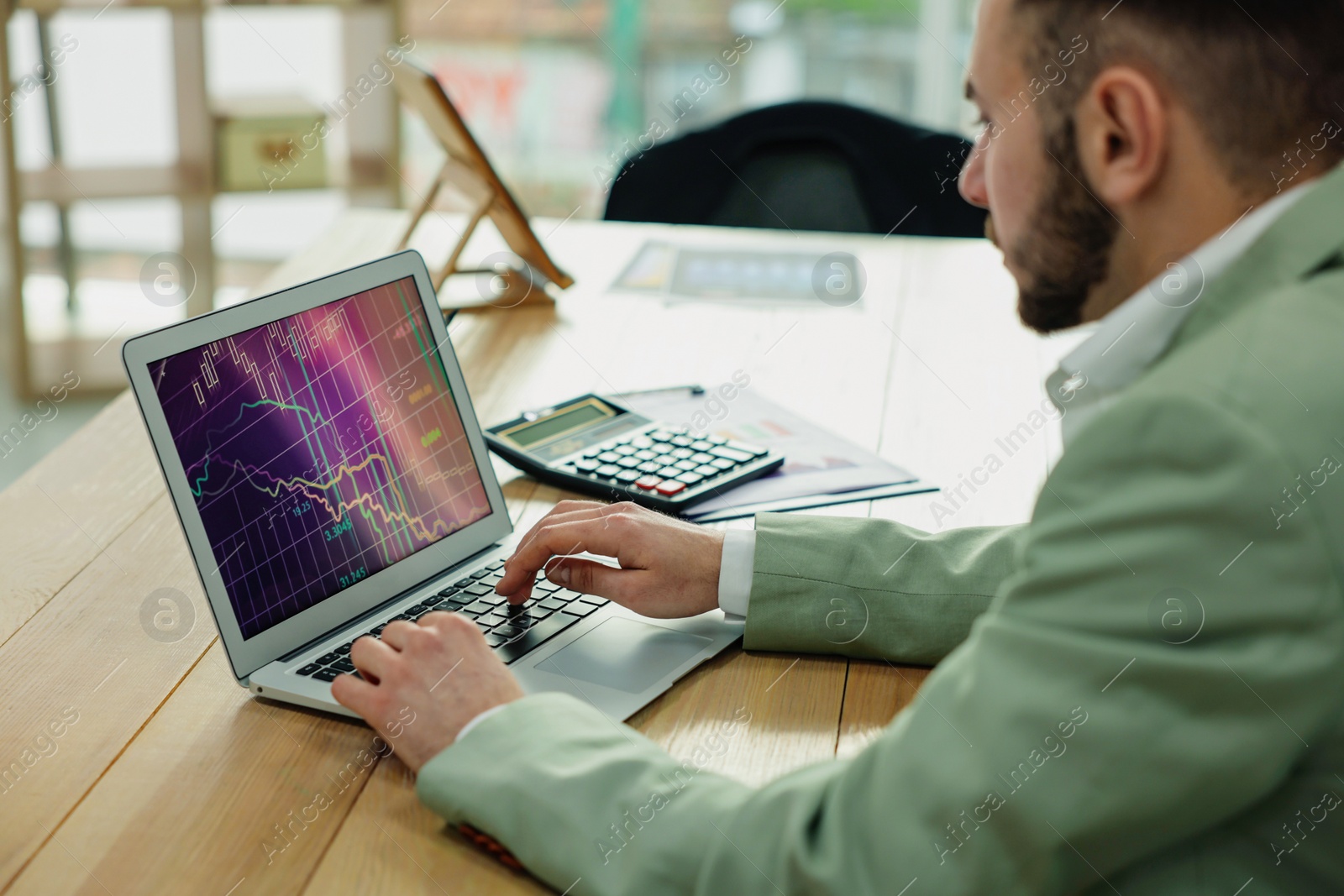 Photo of Broker working with laptop in office. Forex trading