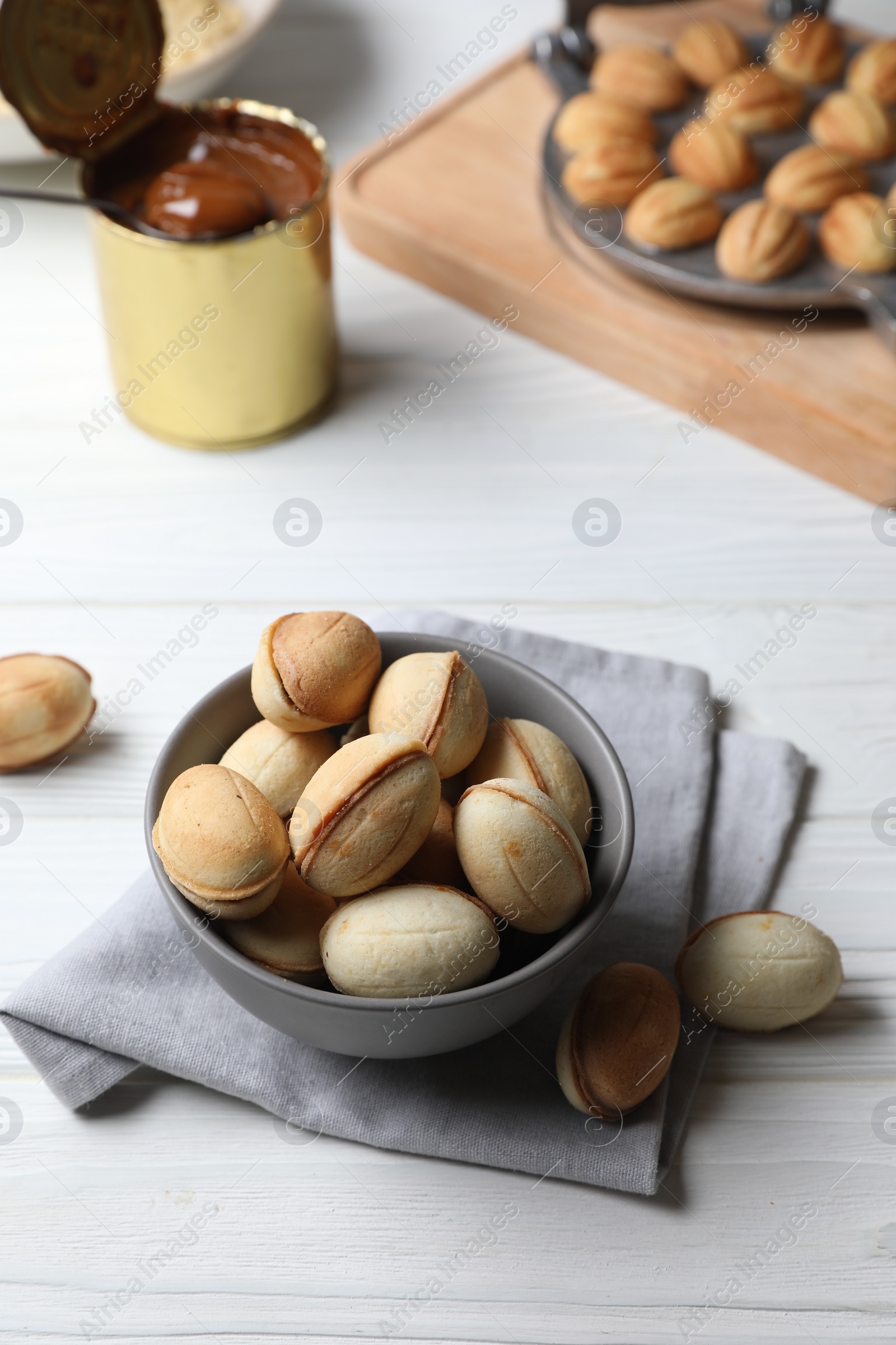 Photo of Delicious walnut shaped cookies with condensed milk on white wooden table