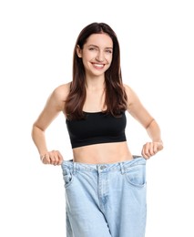 Photo of Happy young woman in big jeans showing her slim body on white background