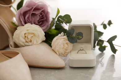 Wedding composition with engagement ring on light grey marble table, closeup. Bride dressing