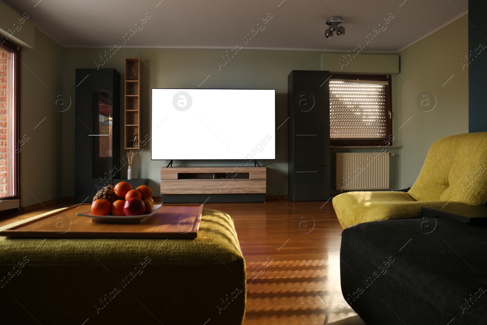 Photo of Stylish room with beautiful furniture and TV set on table. Interior design