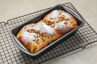 Delicious yeast dough cake in baking pan on marble table