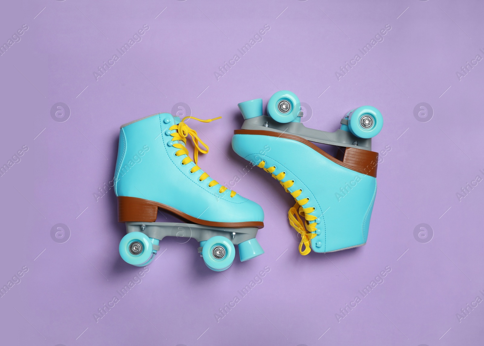 Photo of Pair of stylish quad roller skates on color background, top view