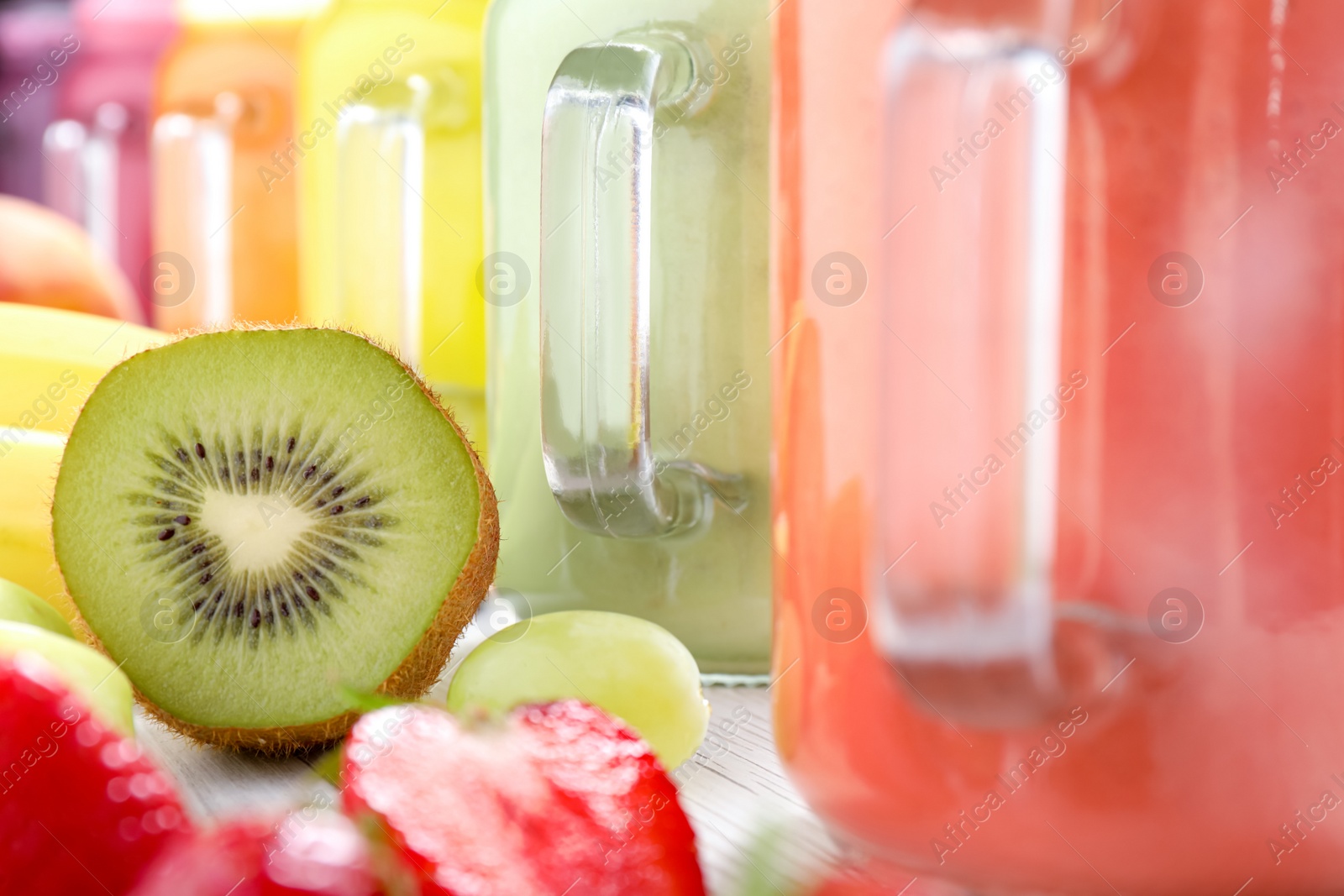 Photo of Different tasty smoothies and ingredients on table, closeup