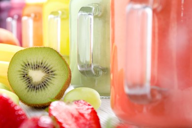 Photo of Different tasty smoothies and ingredients on table, closeup