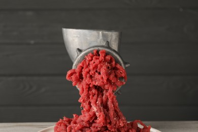 Photo of Metal meat grinder with beef mince against grey background