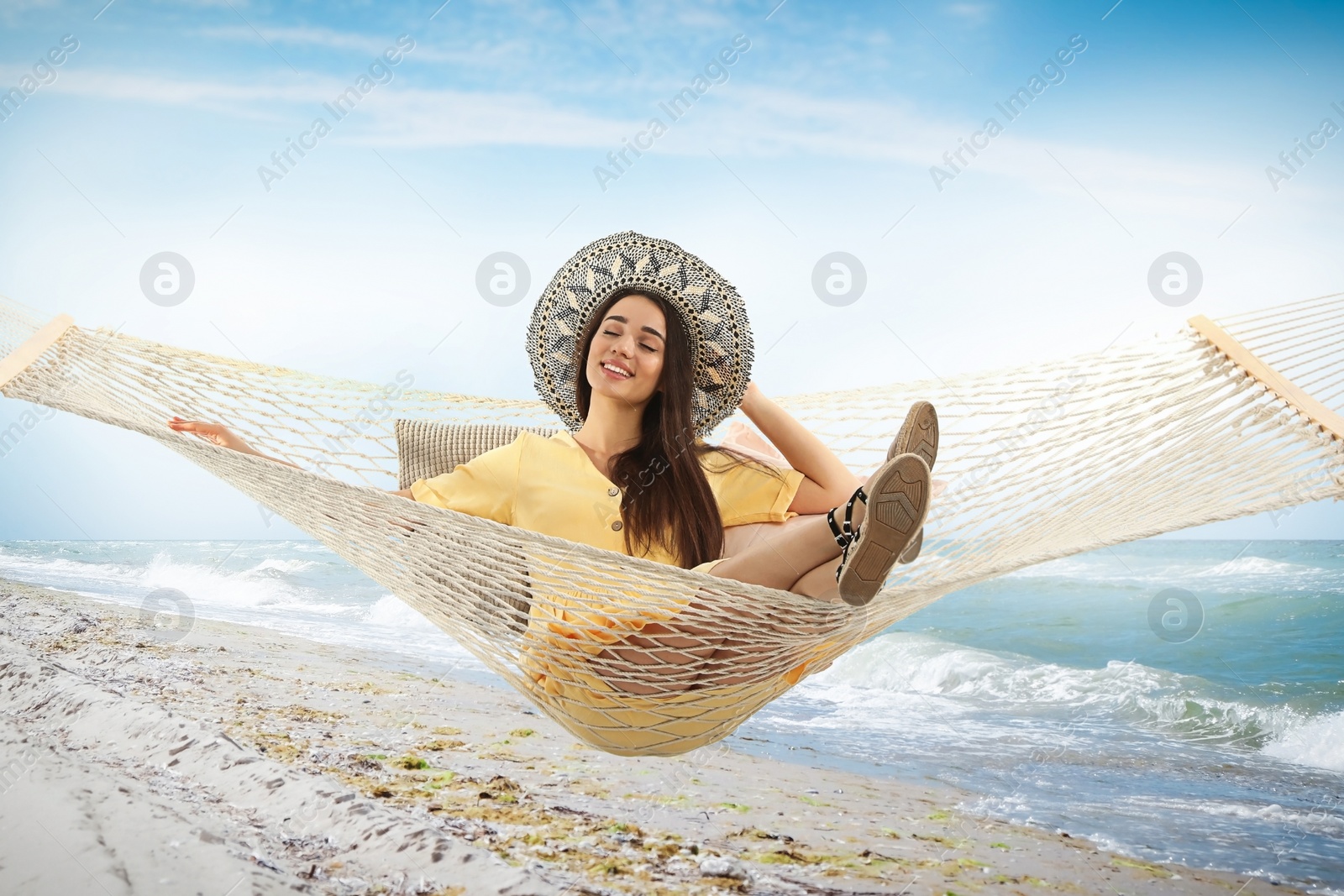 Image of Woman resting in hammock near sea on sunny day 