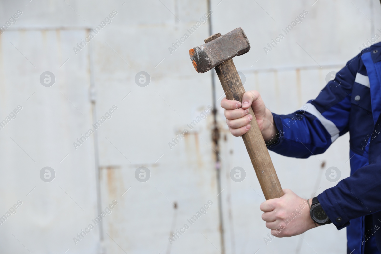 Photo of Man with sledgehammer outdoors, closeup. Space for text