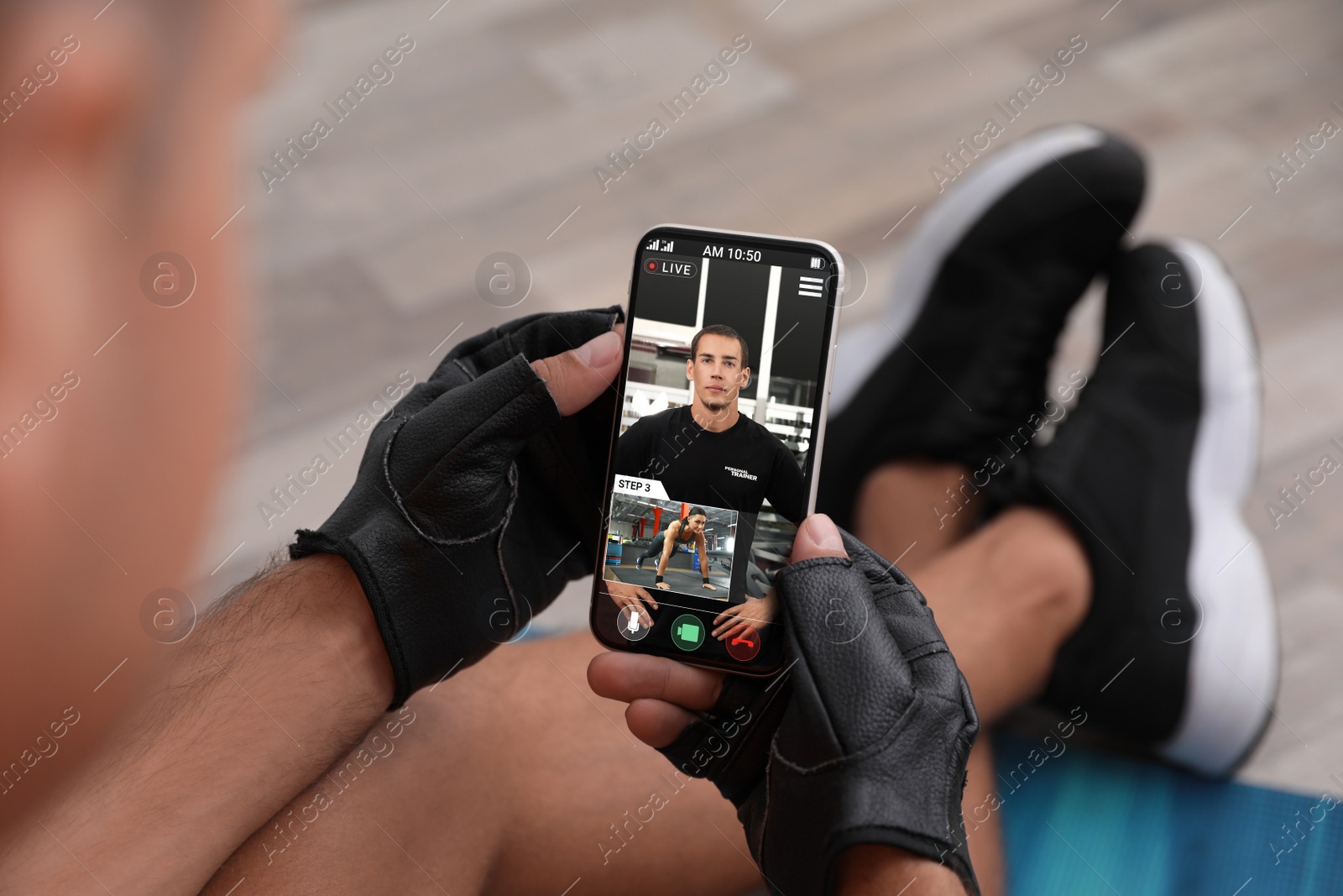 Image of Man having workout with personal trainer via smartphone at home, closeup