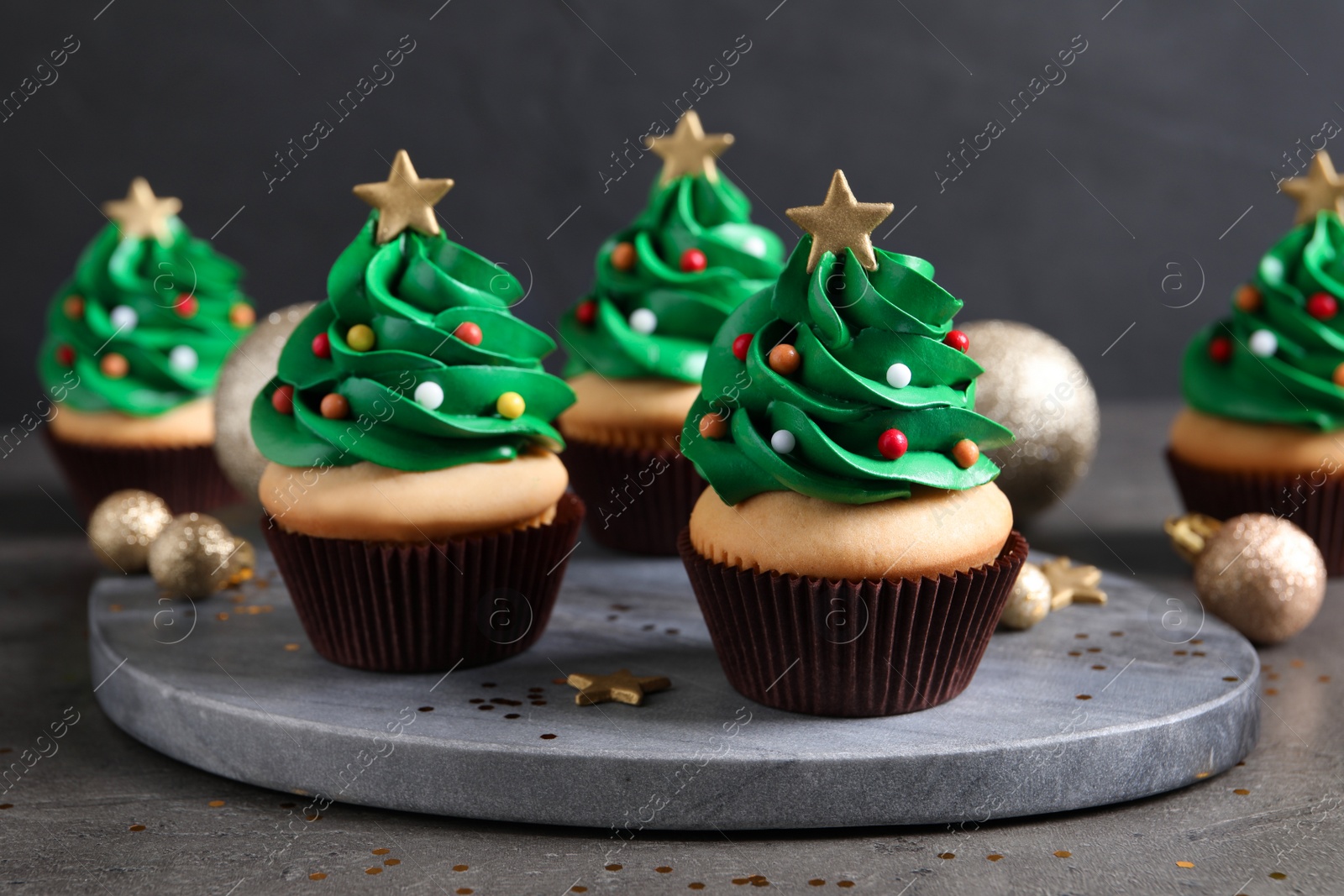 Photo of Christmas tree shaped cupcakes on grey table