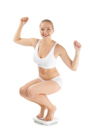 Beautiful young woman on scales against white background. Healthy diet