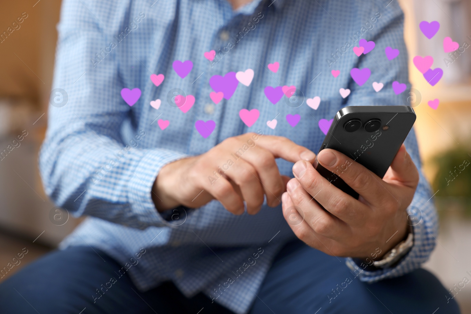 Image of Long distance love. Man sending or receiving text message, closeup. Hearts flying out of device