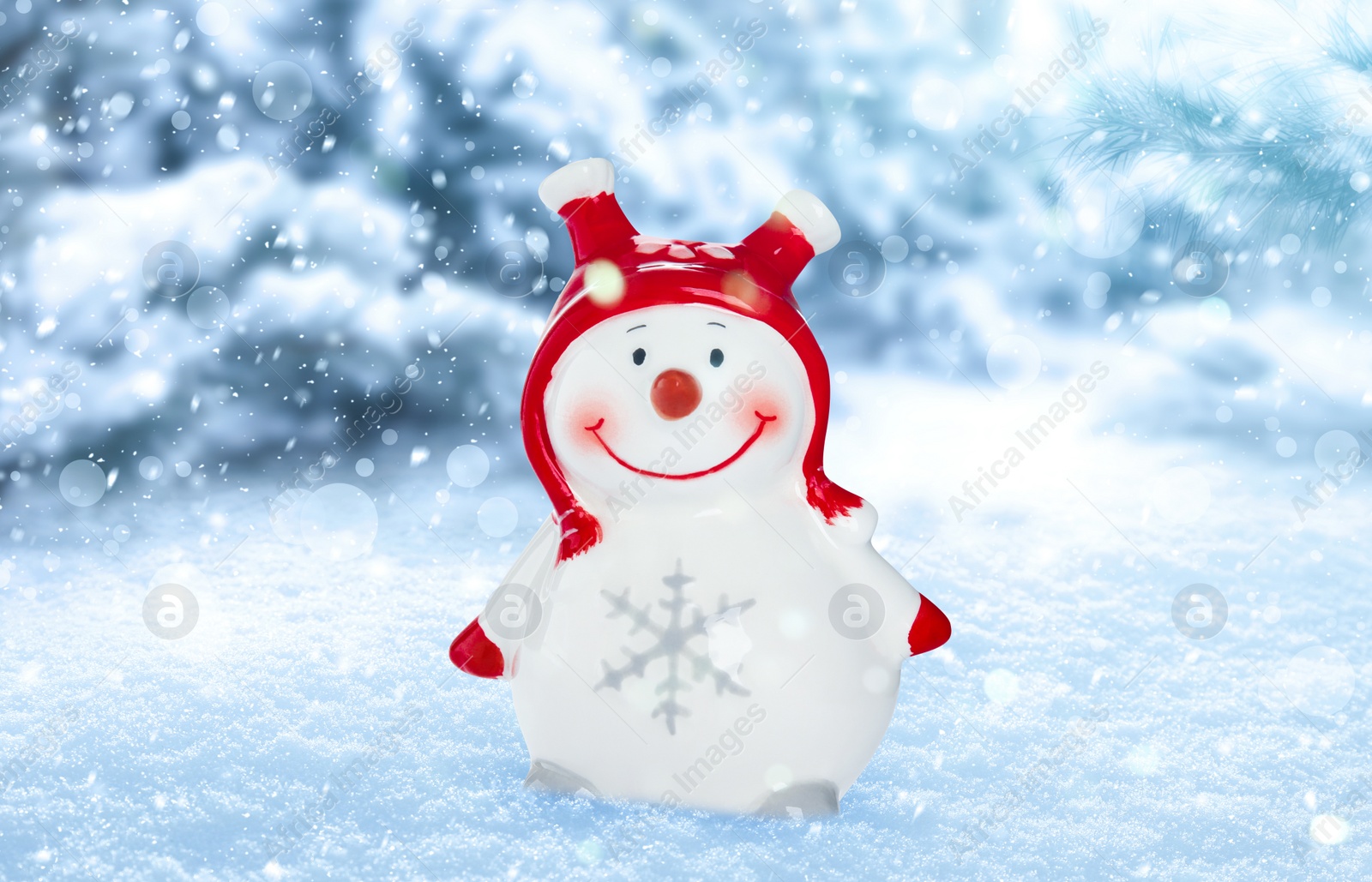 Image of Cute decorative snowman outdoors on snowy day