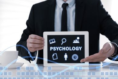 Psychologist with modern tablet at white table in office, closeup 