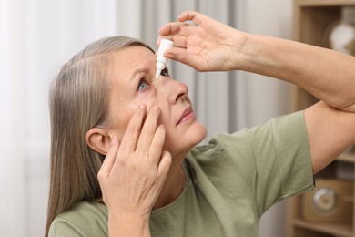 Woman applying medical eye drops at home