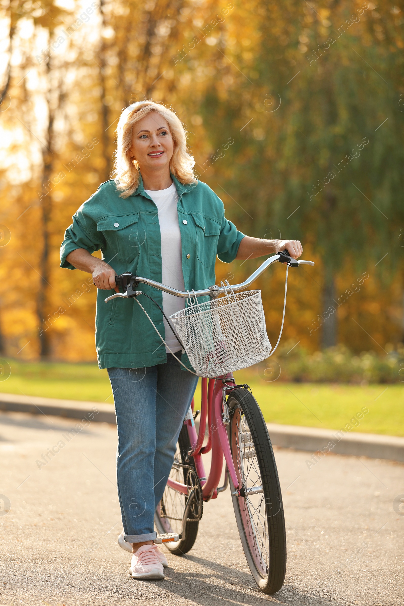 Photo of Mature woman with bicycle outdoors. Active lifestyle