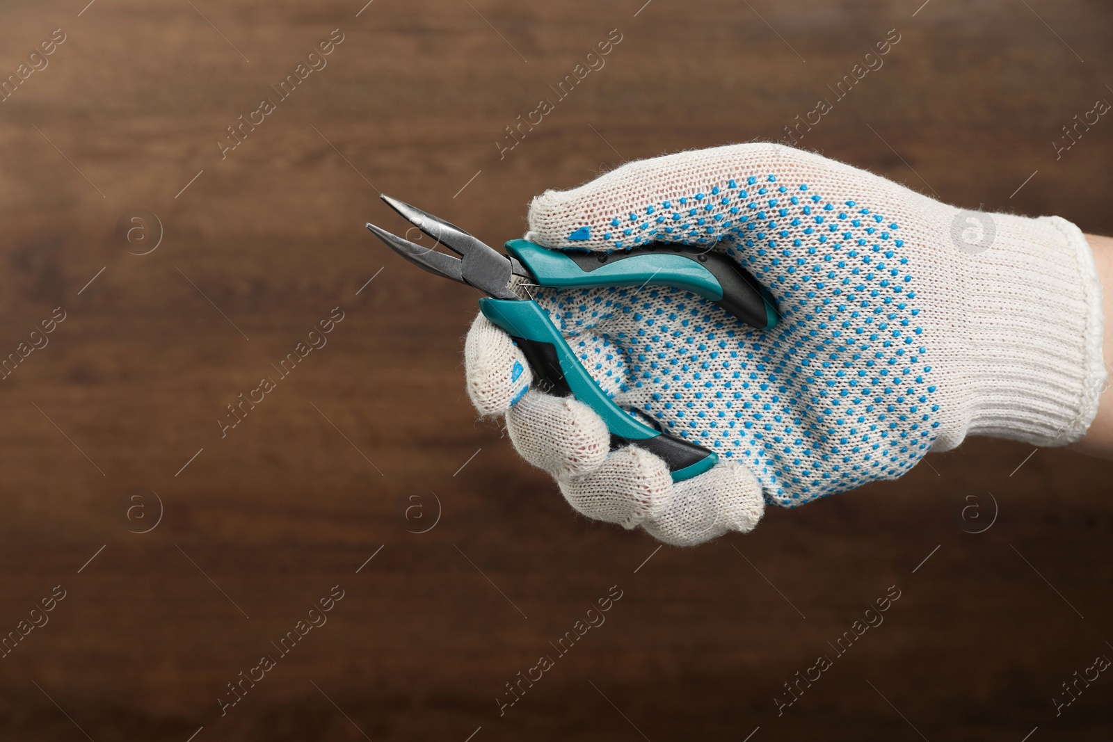 Photo of Man with bent nose pliers on wooden background, closeup. Space for text