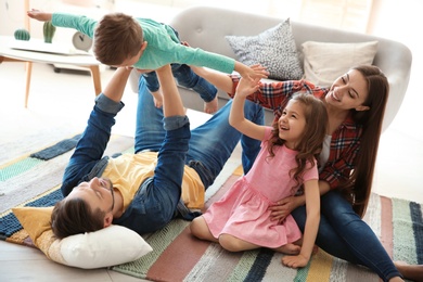 Young couple spending time with children at home. Happy family