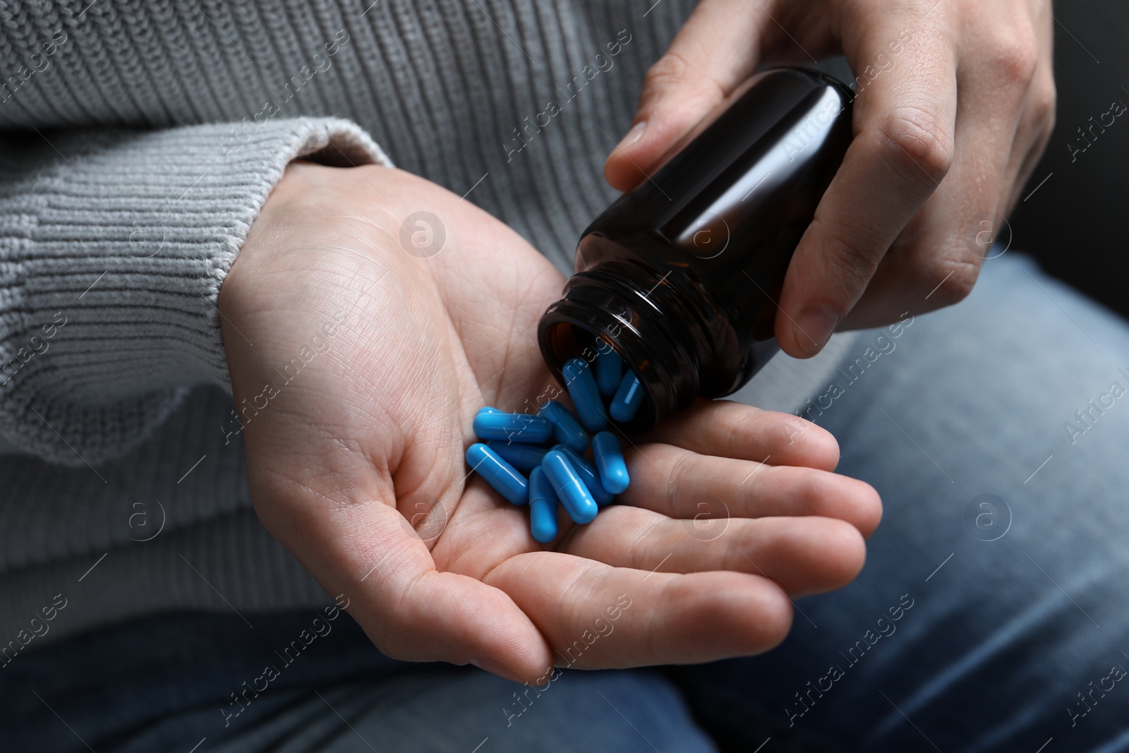 Photo of Man pouring pills from bottle, closeup view