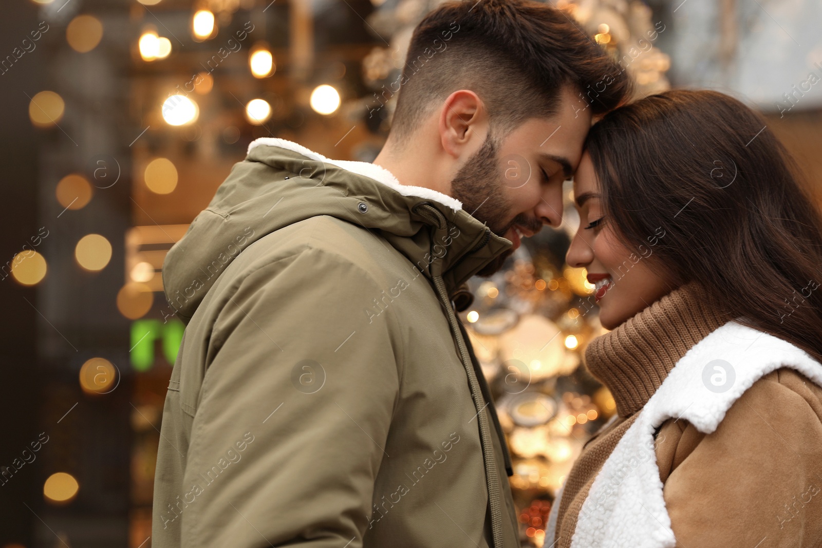 Photo of Lovely couple near store decorated for Christmas outdoors
