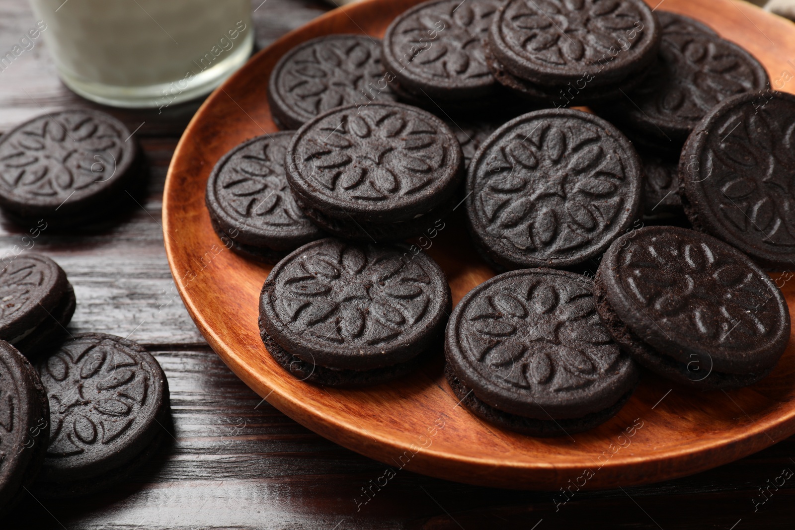 Photo of Plate with tasty sandwich cookies on wooden table, closeup