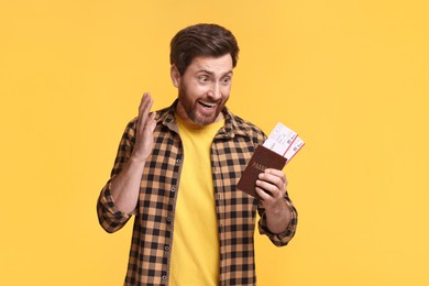 Emotional man with passport and tickets on yellow background