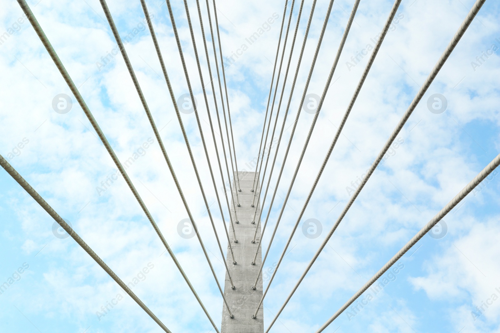 Photo of Beautiful modern bridge against blue cloudy sky, low angle view